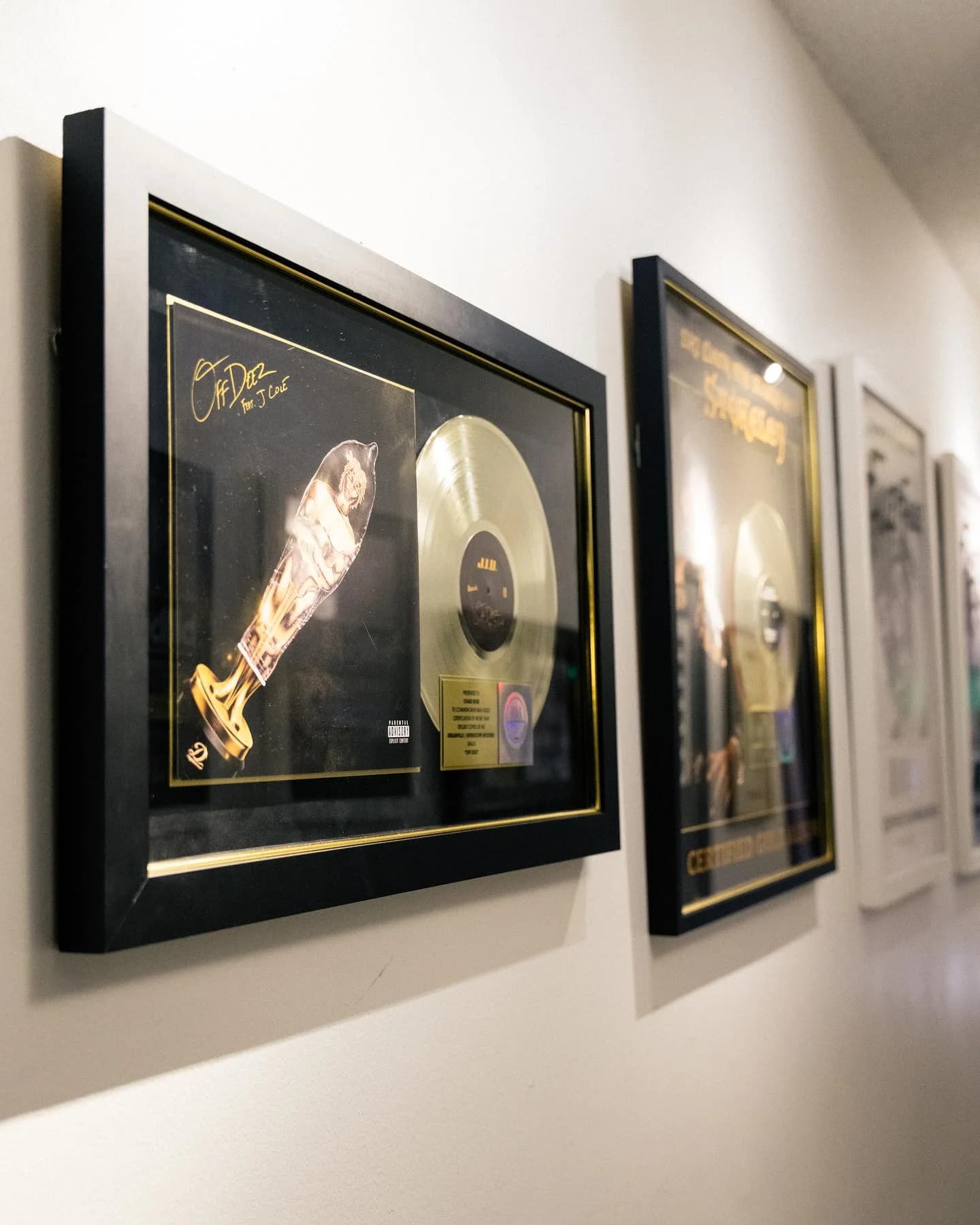 Framed gold record and album display in the studio hallway