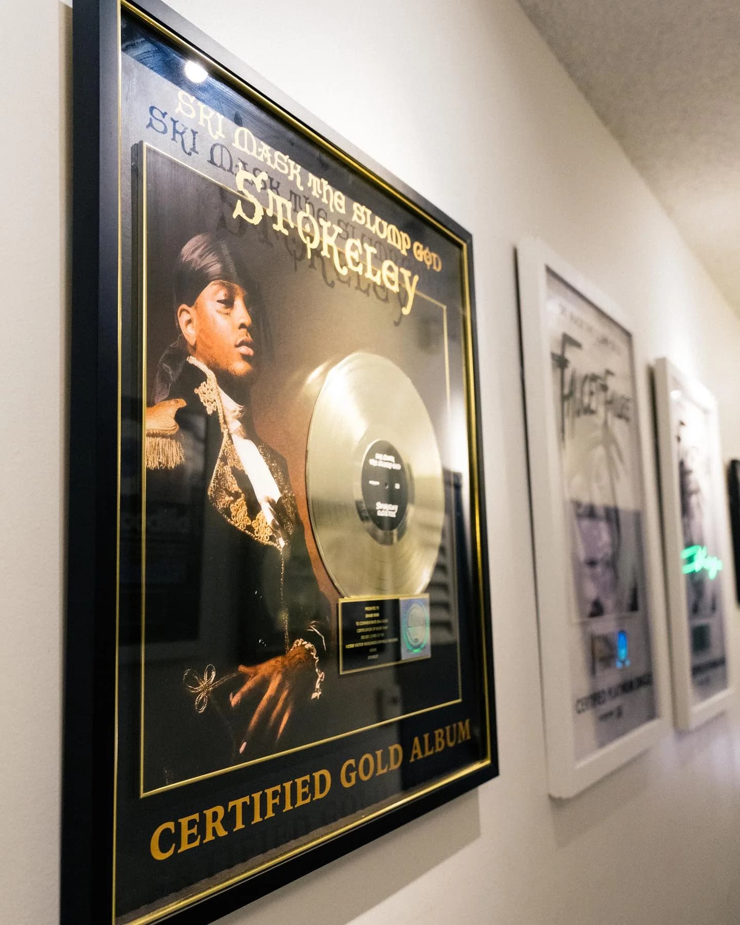 Framed certified gold record displayed in the studio hallway