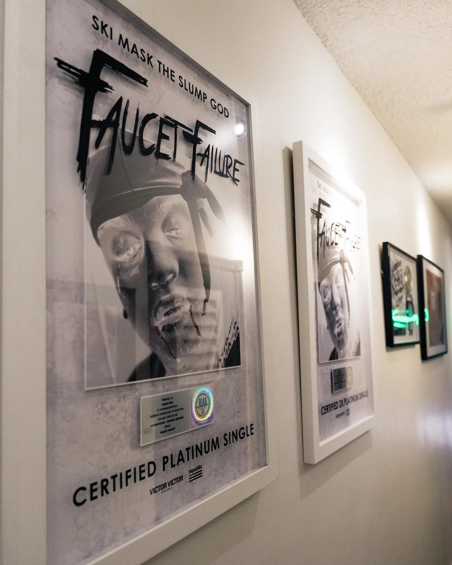 Framed platinum single display in the studio hallway