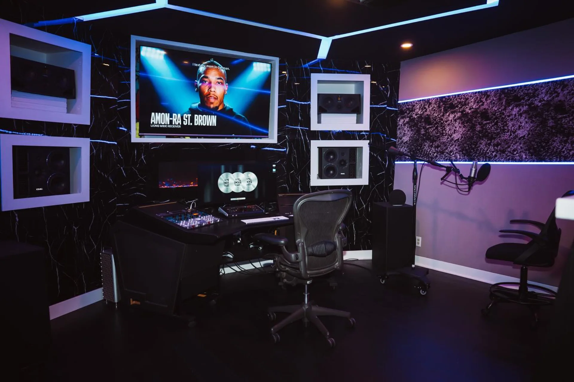 Studio A with illuminated acoustic treatment and a central production desk